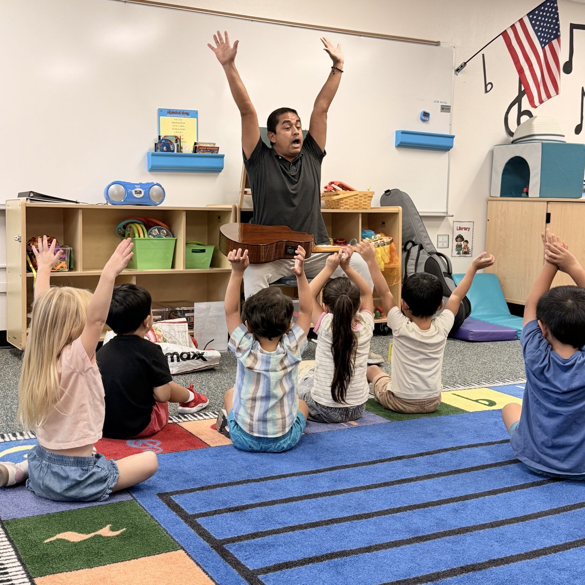 An OC Music Services teacher leading a preschool class in a music game
