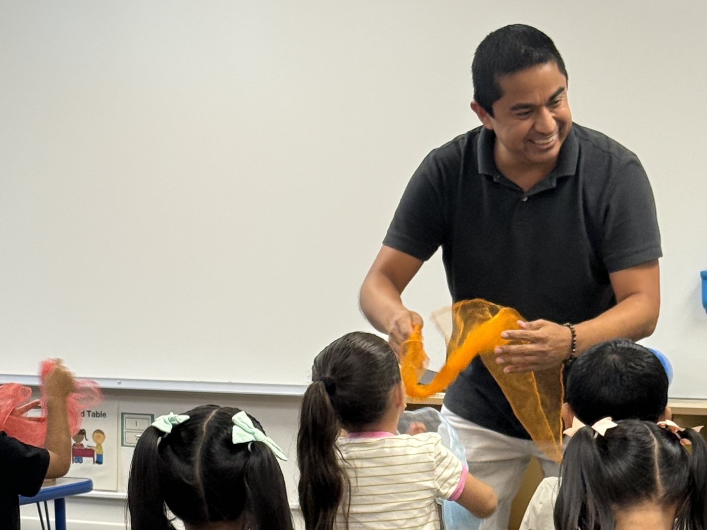 An OC Music Services teacher leading a scarf movement activity with preschoolers