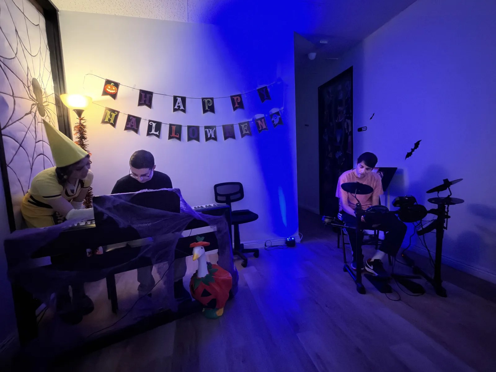 Teens playing piano and electronic drums at an OC Music Services music night